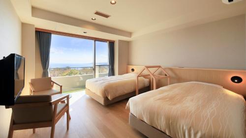 a hotel room with two beds and a large window at ゆるり熱海withDOGS in Atami