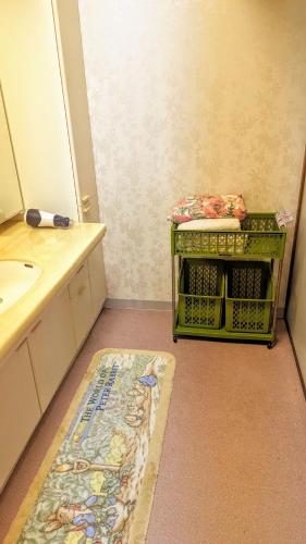 a bathroom with a sink and a rug on the floor at ゲストハウスヒスイ in Kuchi-sada
