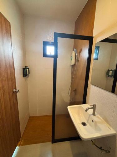 a bathroom with a sink and a shower with a phone at The Connect Chiang Mai in Chiang Mai