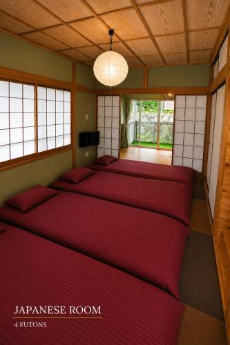 a japanese room with red beds in it at Ranked 1 in the Izu Mount Fuji from the villa in Izunokuni
