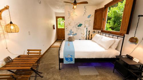 a bedroom with a bed and a wooden bench at Finca Ki' - Eco Farm Stay Bed & Breakfast - El Yunque Region in Naguabo