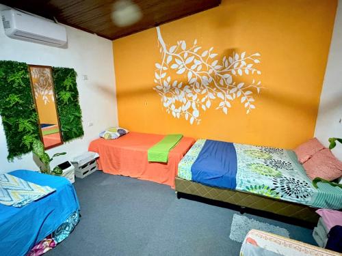 a room with two beds and a painting on the wall at Passifloras Hostel in Quepos
