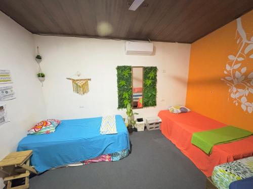 two beds in a room with colorful walls at Passifloras Hostel in Quepos