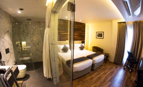 a hotel room with a bed and a shower at Connaught Royale Delhi in New Delhi