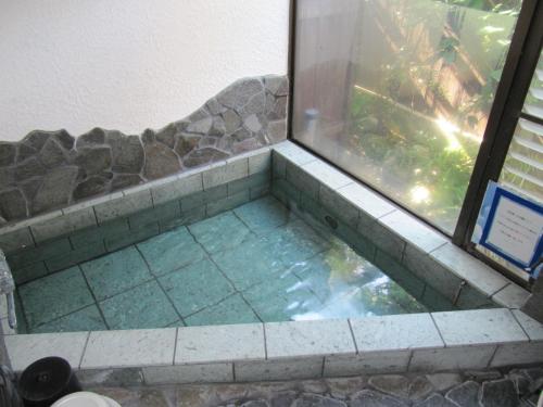 a walk in shower with a window in a bathroom at Chateau Le Fleur in Ito