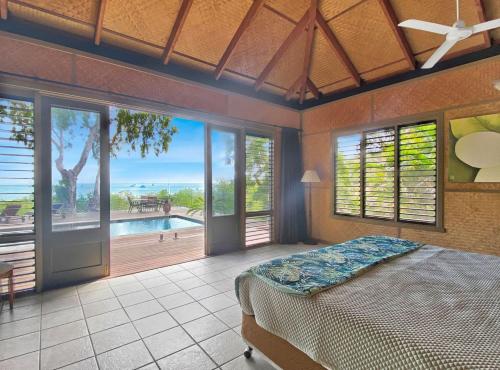 a bedroom with a bed and a view of a pool at Absolute Beachfront and Pool House in Horseshoe Bay