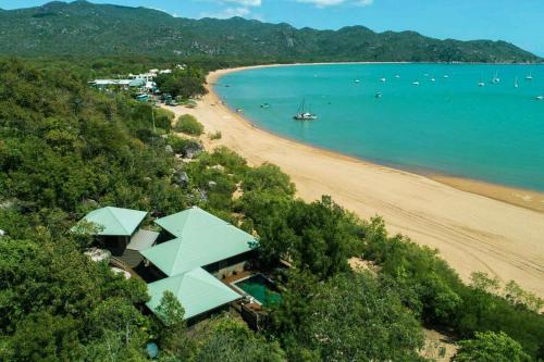 a view of a beach with a house and the ocean at Absolute Beachfront and Pool House in Horseshoe Bay