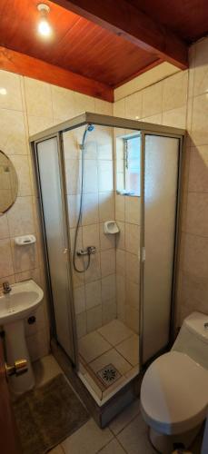 a bathroom with a shower with a toilet and a sink at Lalck Cketi Hotelería y Turismo in San Pedro de Atacama