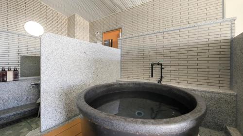 a large tub in a bathroom with a sink at ゆるり熱海withDOGS in Atami