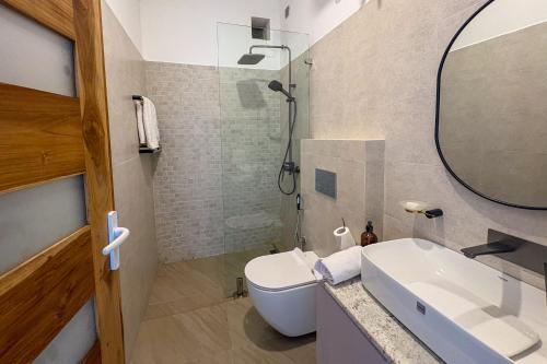 a bathroom with a sink and a toilet and a mirror at Mora Mila in Arugam Bay
