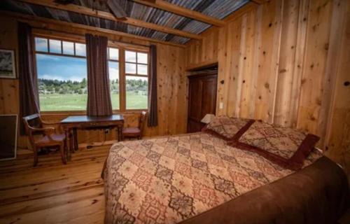 a bedroom with a bed and a desk and a window at Couples Country Getaway in Pagosa Springs