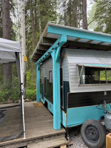 a blue and white trailer with a porch and stairs at Cozy Vintage Camper, the Tealy Wheely in Golden