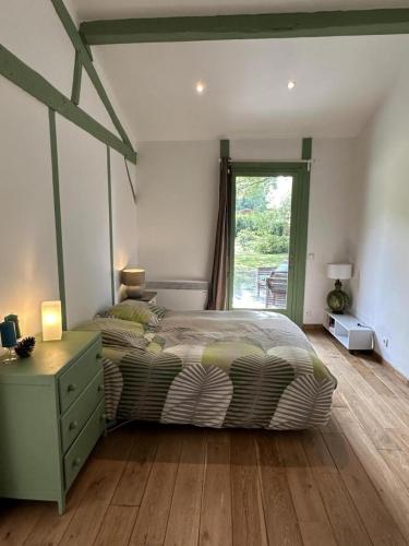 a bedroom with a bed and a dresser and a window at Bois sauvage in Parentis-en-Born