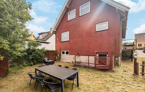 a large red house with a picnic table in front of it at Beautiful Home In Allinge With Wifi in Allinge