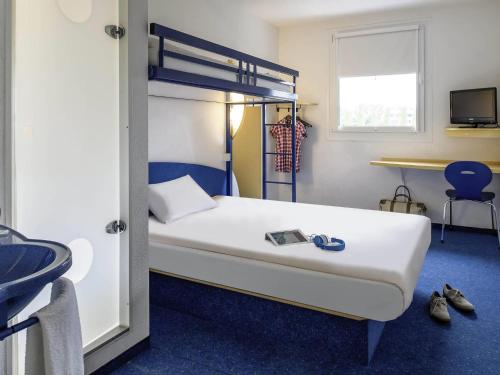 a bedroom with a bunk bed and a sink at ibis budget Bar le Duc in Bar-le-Duc