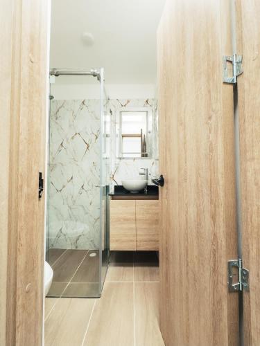 a bathroom with a sink and a glass shower door at Colseguros in Cali