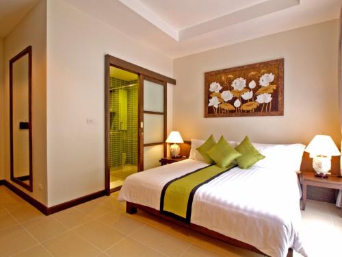 a bedroom with a large white bed with green pillows at The Sea View Residence in Ban Bang Bao