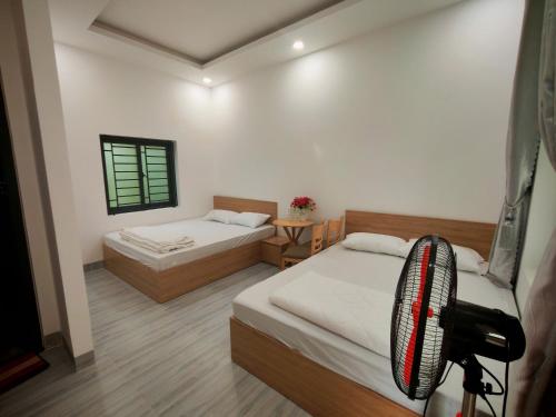 a bedroom with two beds and a chair in it at Một Eco-Lodge in Tân Phú