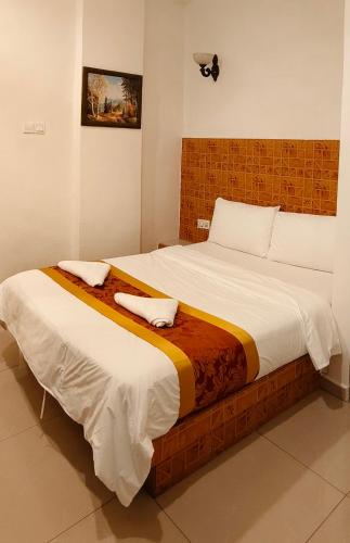a bedroom with a large bed with two pillows on it at Hotel Seri Nilai in Nilai