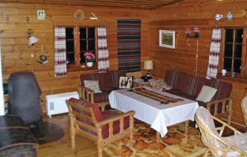 una sala de estar con mesa y sillas en una cabaña en Nesheim Cabin-By-The-Sea, en Øygarden
