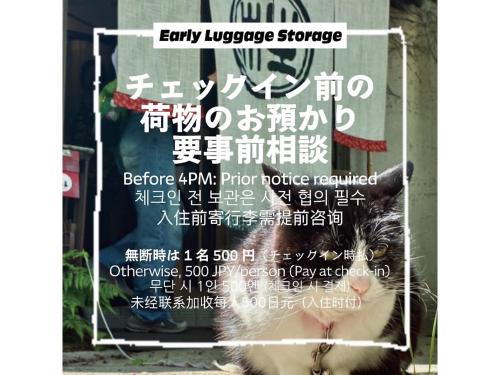 a sign with a cat sitting in front of a store at The Otaornai Backpacker's Hostel Morinoki in Otaru