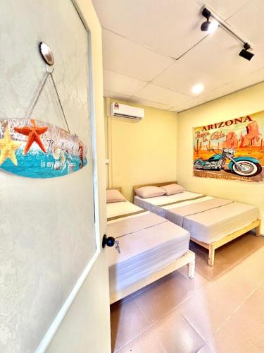 a room with two beds and a door at Camp Fire Homestay 2602 in Mersing