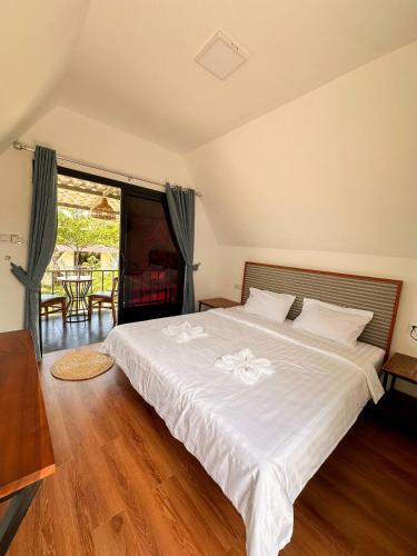 a bedroom with a large white bed and a large window at Sunrise Bungalows in Kaôh Rŭng (3)