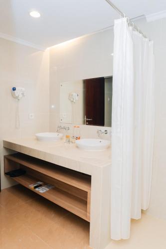 a bathroom with two sinks and a mirror at BRITS HOTEL PANGKALAN BUN in Pangkalan Bun