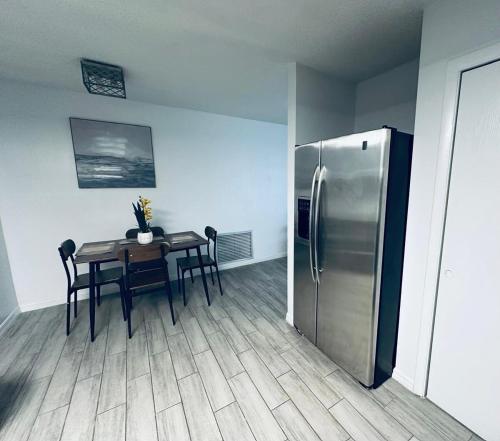 a kitchen with a table and a stainless steel refrigerator at Beautiful Brand-New studio in New Port Richey