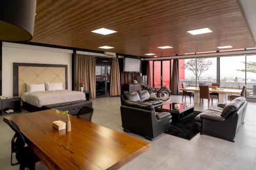a living room with a bed and a table and chairs at Kalya Hotel Bandung Dago in Bandung