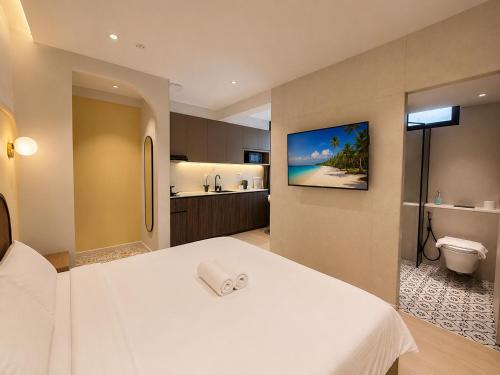 a hotel room with a white bed and a bathroom at ISA Hotel Amber Road in Singapore