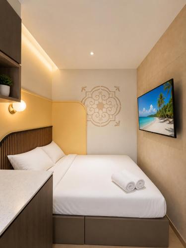 a small bedroom with a bed with white sheets at ISA Hotel Amber Road in Singapore