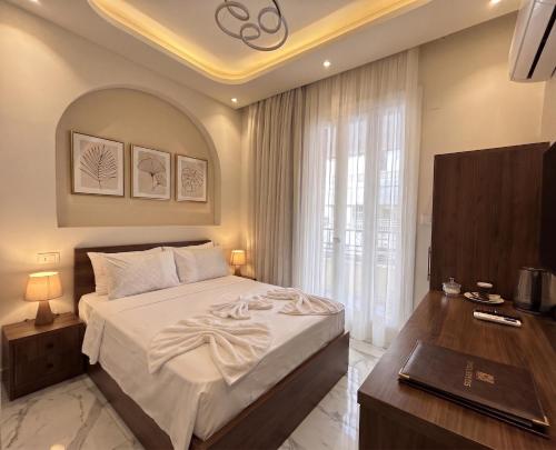 a bedroom with a bed and a desk and a window at Maravia downtown hotel in Cairo
