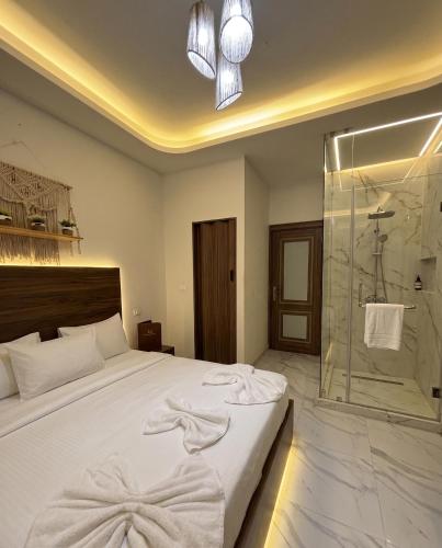 a bedroom with a bed and a glass shower at Maravia downtown hotel in Cairo