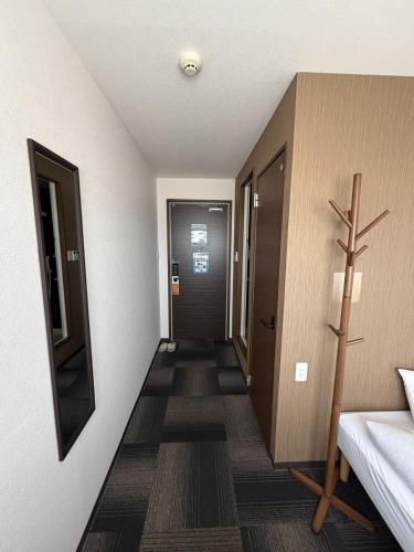 a room with a hallway with a cross on the wall at Hotel The Namie Terrace in Namie