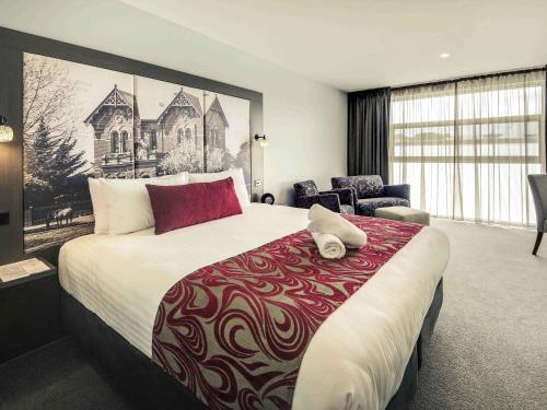 a hotel room with a large bed and a chair at Mercure Warragul in Warragul