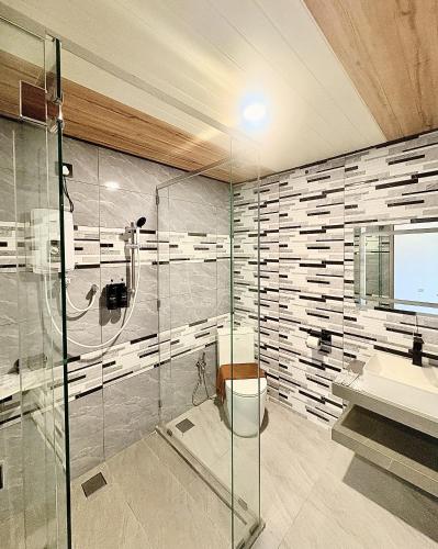 a bathroom with a shower and a toilet and a sink at Kea Garden Guest House in Brinchang