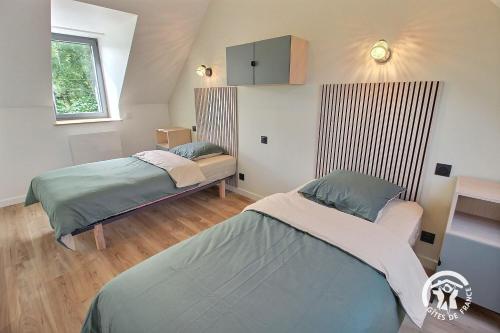 a bedroom with two beds in a room at Ty prad in Lanvellec