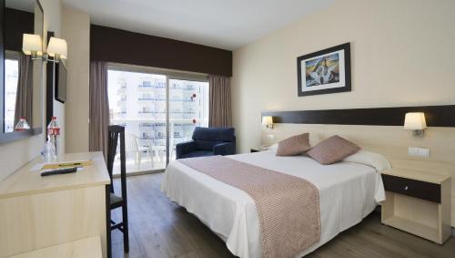a hotel room with a bed and a desk and a chair at Sandos Griego in Torremolinos