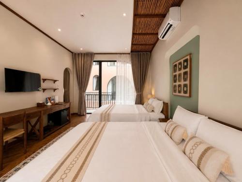 a hotel room with two beds and a television at Soho Boutique in Quảng Ngãi