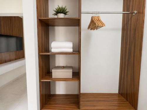 a closet with wooden shelves and a tv at Lucmar Jardín boutique in Cuernavaca