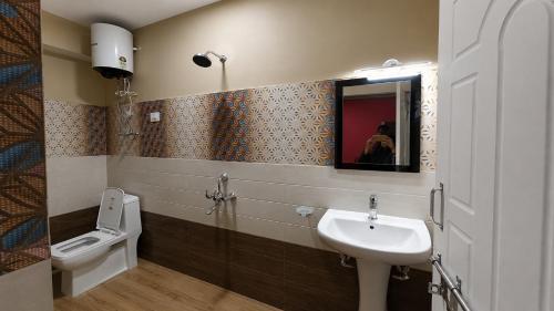 a bathroom with a sink and a toilet and a mirror at Hotel Sai Kripa, sikkim in Ravangla