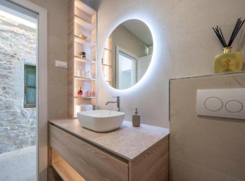 a bathroom with a sink and a mirror at Apartman Dolce in Trpanj