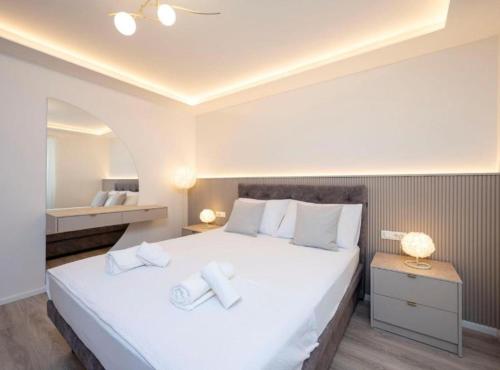 a bedroom with a large white bed with towels on it at Apartman Dolce in Trpanj