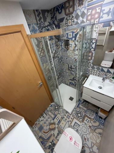 a bathroom with a shower and a toilet and a sink at Ático BELLAVISTA -4 habitaciones dobles 2 baños completos y visita a bodega- in Tudela