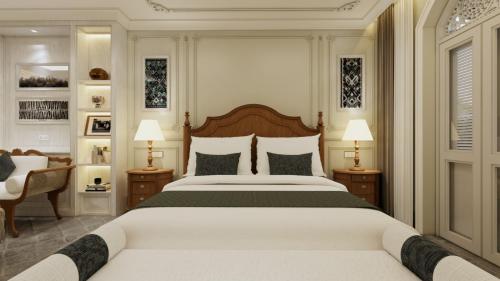 a bedroom with a large white bed and two lamps at Villa Santi Hotel in Luang Prabang