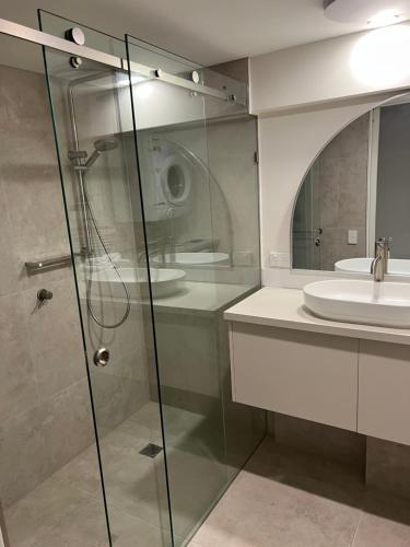 a bathroom with a glass shower and a sink at Horizons At Peregian in Peregian Beach