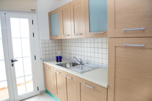 a kitchen with wooden cabinets and a sink at Villas Coloradas in Playa Blanca