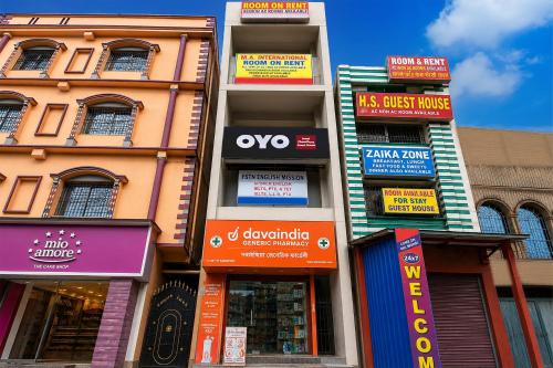 a building with many signs on the side of it at Hotel O Agarpara Railway Station Road Formerly Chowdhury Guest House in kolkata