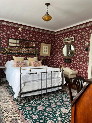 a bedroom with a bed and a table and a mirror at Munroe Inn Boutique Hotel in Auburn